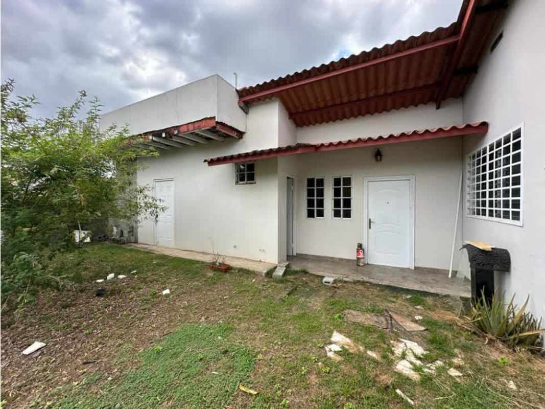 Side view of parking spaces and covered carport in gated house for sale