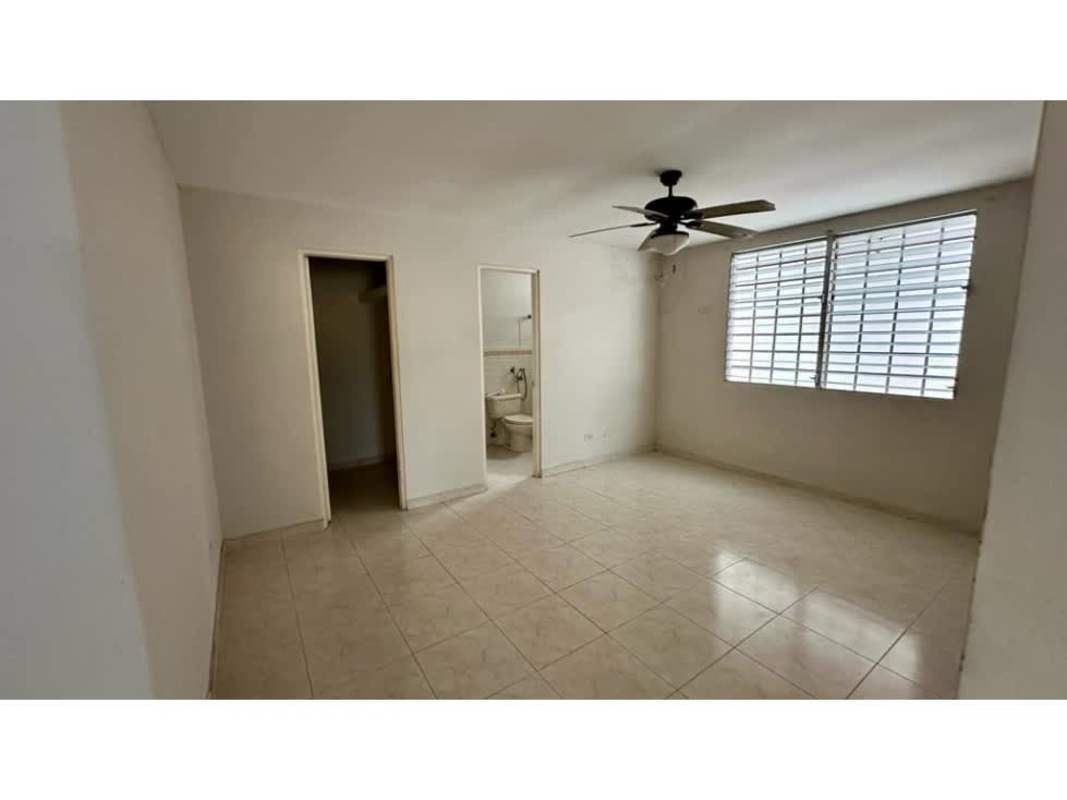 Bright bedroom with tiled floor, large window and ceiling fan at Brisas del Golf