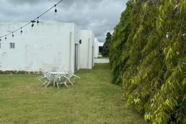Minimalist white facade with garden view backyard and outdoor dining in Ibiza Residences Río Hato