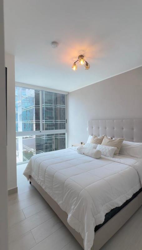 Minimalist bedroom king bed tufted headboard city view window PH Urbana Obarrio