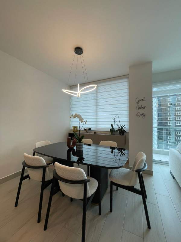 Minimalist dining room black table white chairs large windows in PH Urbana Obarrio