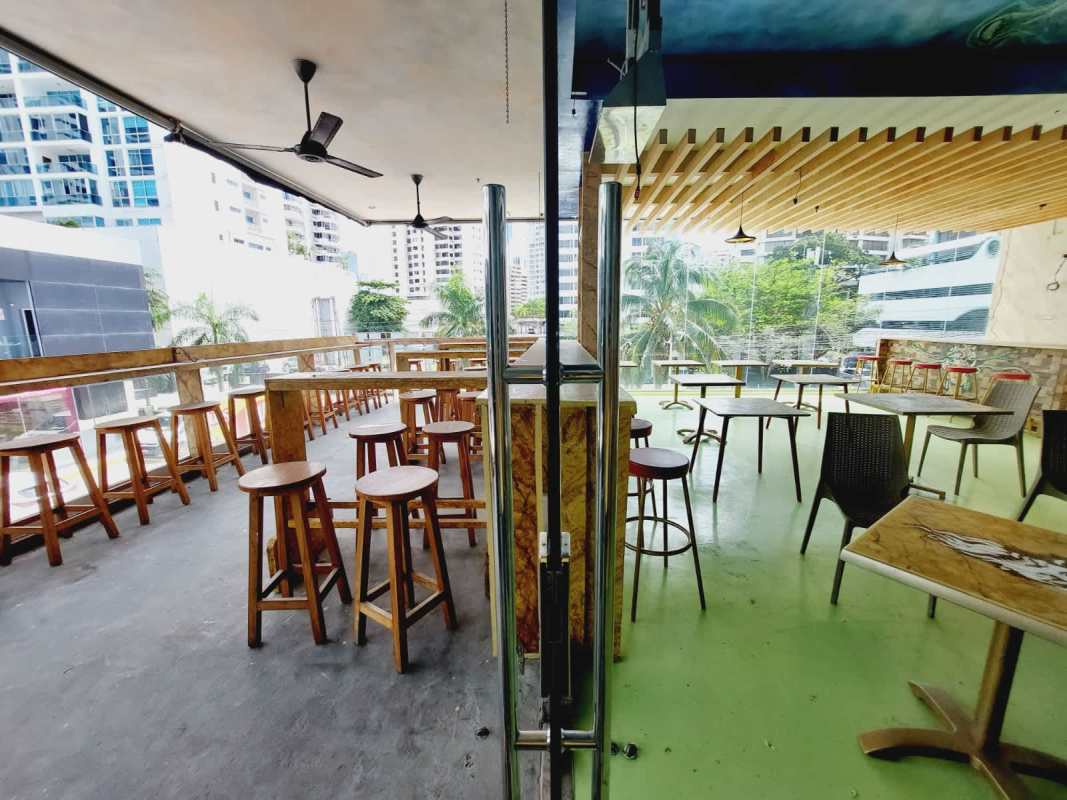 Modern enclosed balcony with bar counter, glass walls, overlooking city and greenery at PH BICSA Financial Center