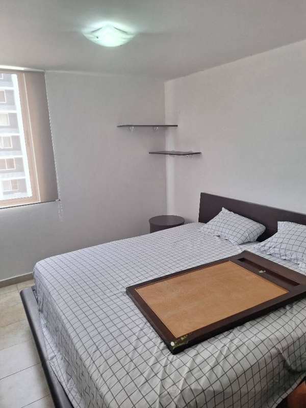 Minimalist bedroom with window, checkered bedding, wood headboard, shelves at PH Cosmopolitan Park Panama.