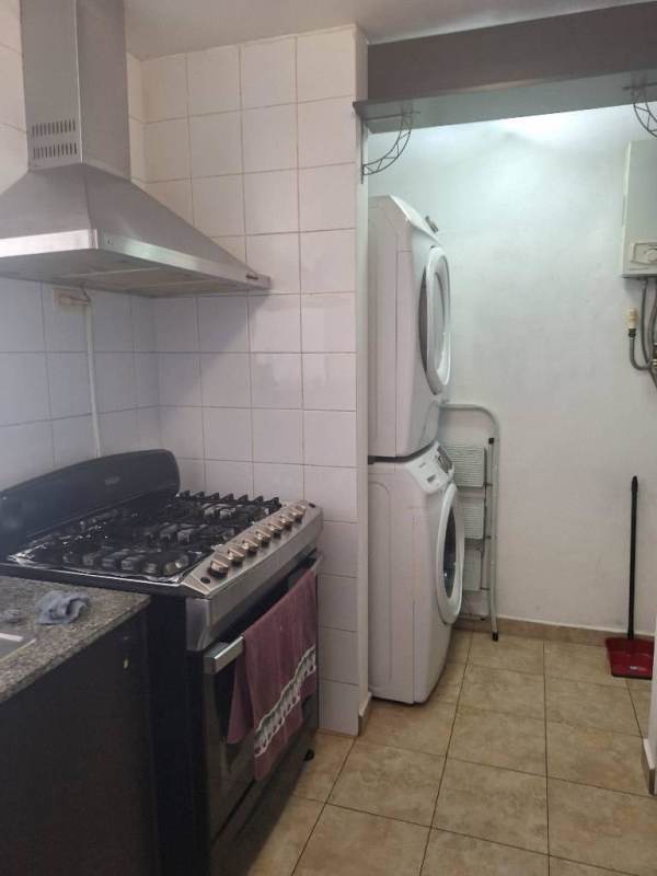 Apartment kitchen with gas stove oven, granite countertop, stacked washer dryer at PH Cosmopolitan Park Panama City.