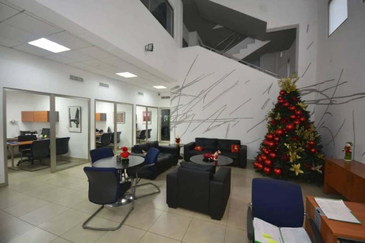 Interior lobby of commercial building with glass cubicles, tile floor and holiday decor in Calle 50 Panama