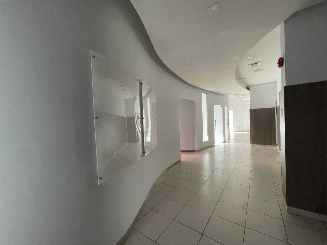 Modern hallway with curved walls and recessed lighting inside PH Aquarius commercial tower Panama