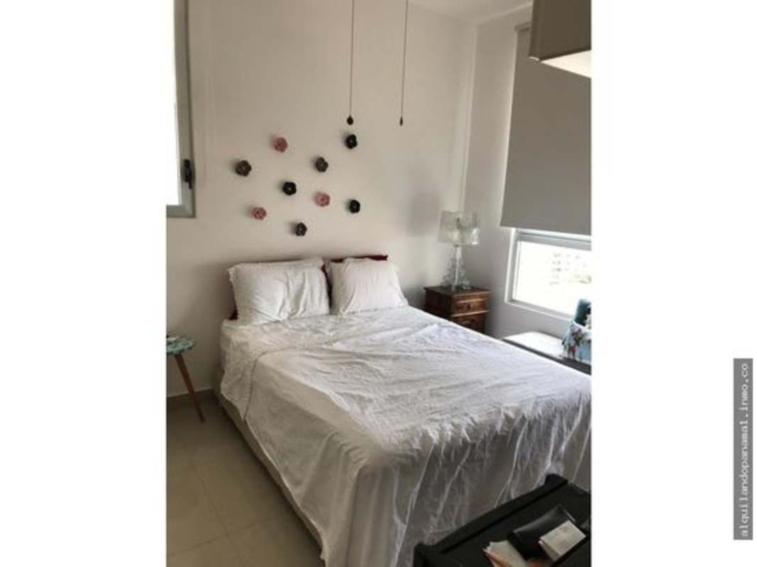 Bedroom with large window with roller blind, blue bedding and minimalist design in PH Vía Porras San Francisco Panama