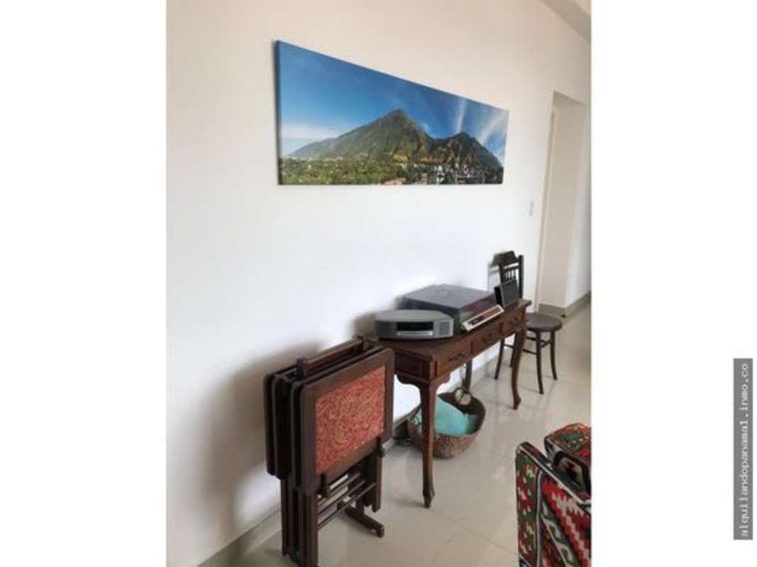 Living room decorated with landscape artwork and vintage furniture at PH Vía Porras San Francisco Panama