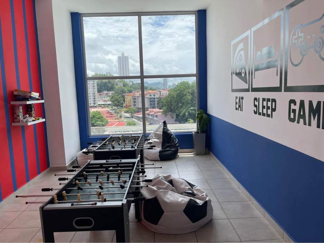 Colorful game room with foosball, bean bags, city skyline views PH Studio 12 Panama City