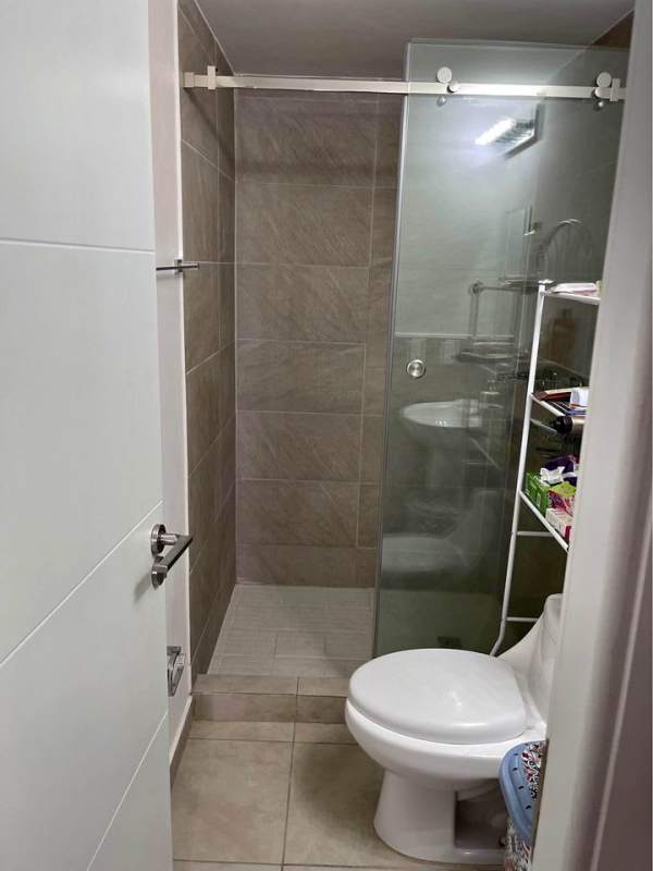 Bathroom with beige tiles, glass shower enclosure, vanity in PH Studio 12 Hato Pintado Panama
