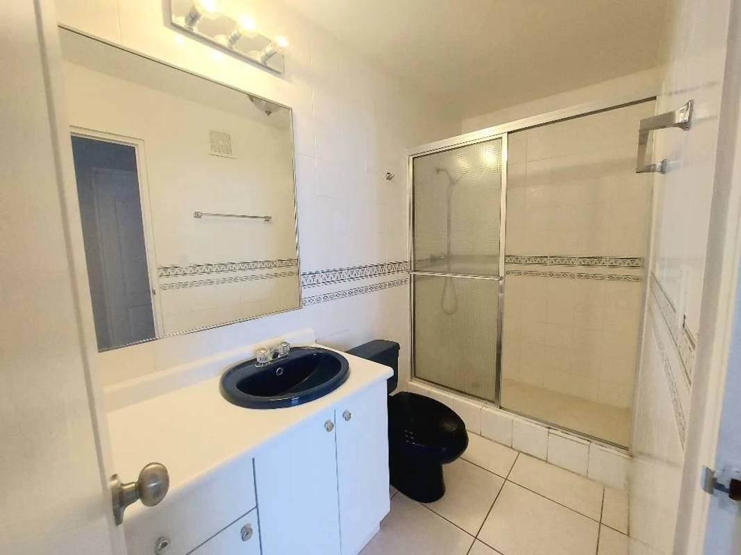 Contemporary bathroom with black fixtures, glass enclosed shower PH Coco del Mar Panama