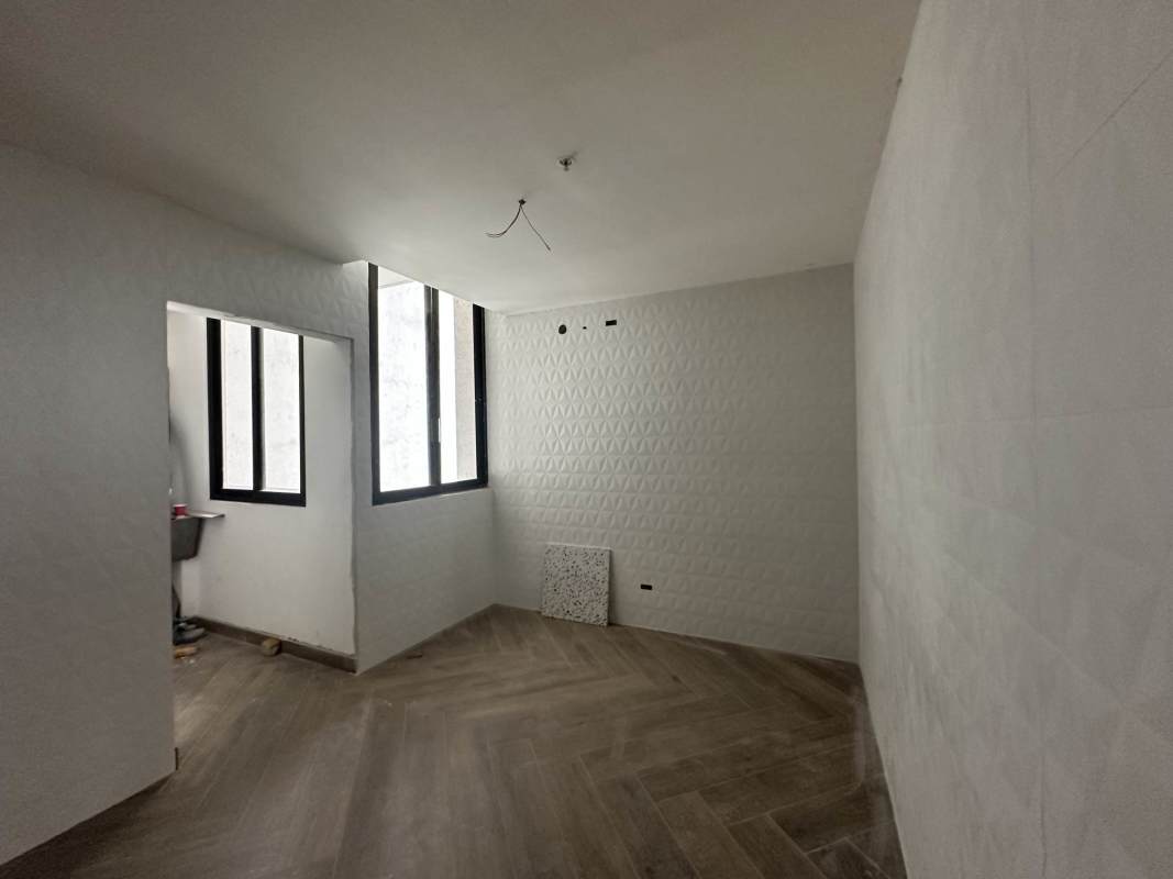 Modern unfurnished bedroom with textured walls and wood-look tile PH Costa del Este Panama City