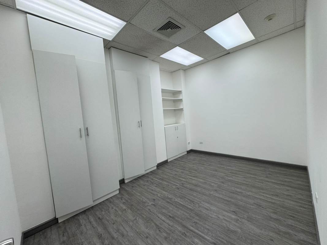 Modern office with dark floors, glass doors and drop ceiling inside PH BICSA Tower Panama City