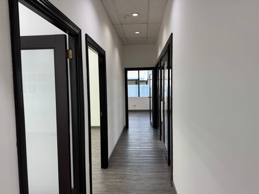 Minimalist commercial office hallway with glass doors and natural light PH BICSA Panama