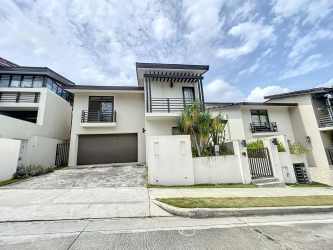 Exterior view of two-story house with balconies, garage, and landscaping in PH Nativa