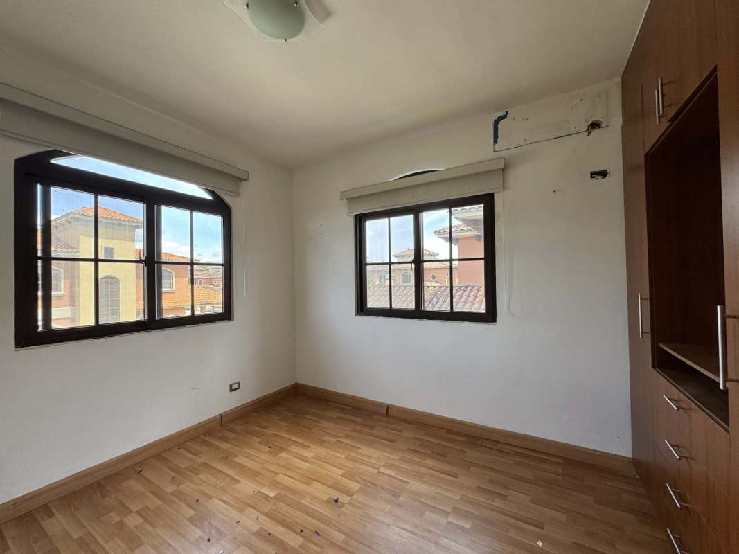 Bright empty living room with wood flooring and large windows in Costa Sur Panama house