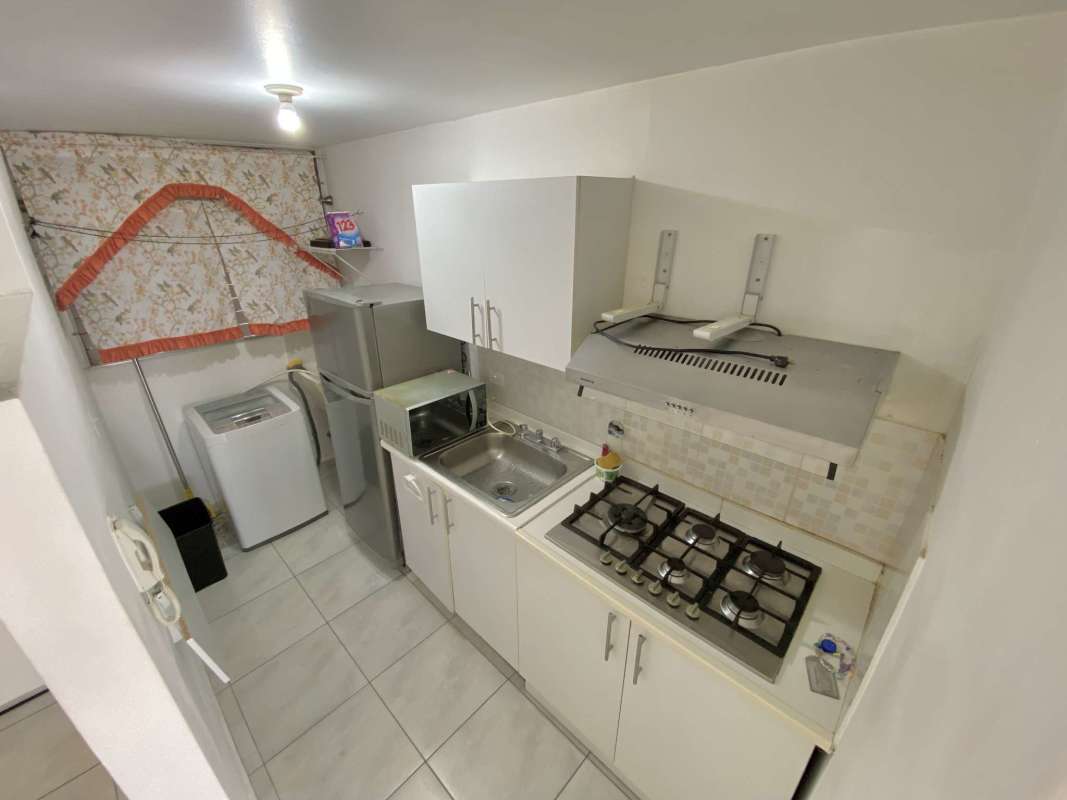 Laundry utility area with fridge microwave washing machine and sink at Llano Bonito Park Panama