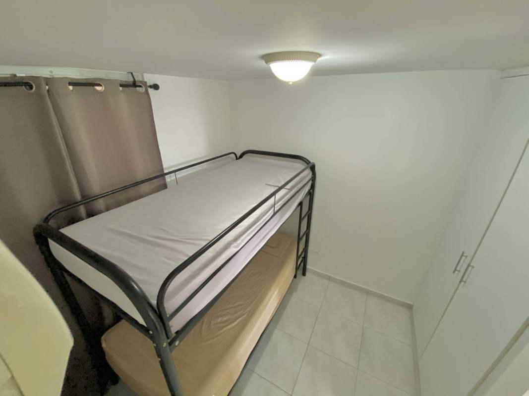 Compact kitchen with granite counters white cabinets washing machine stove microwave in Llano Bonito Park Panama