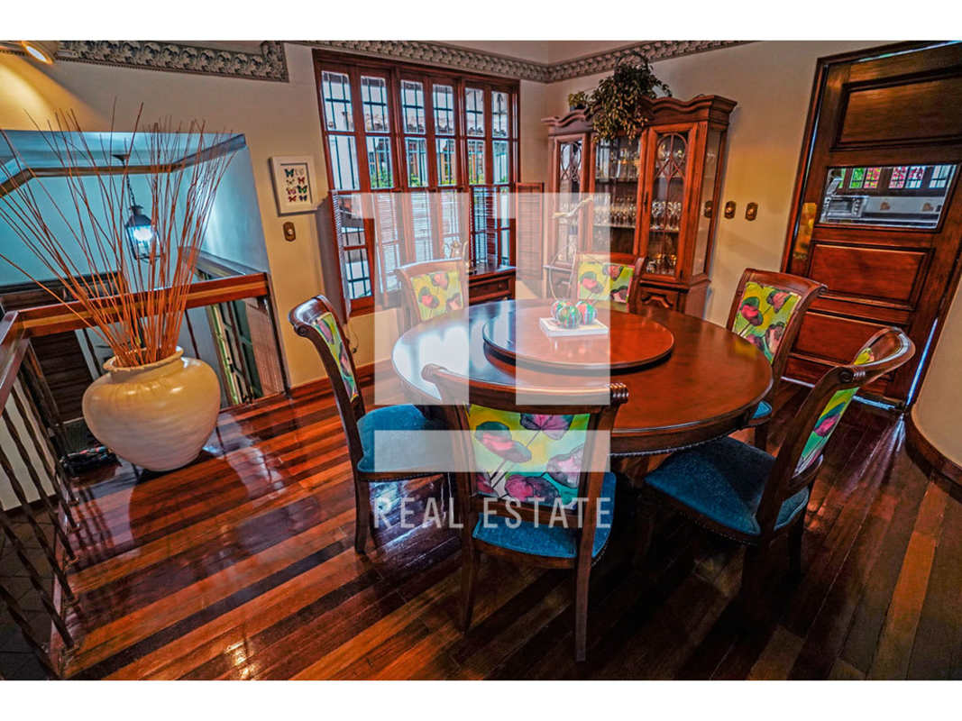Formal dining room with hardwood floor, round wooden table and large window in Panama City