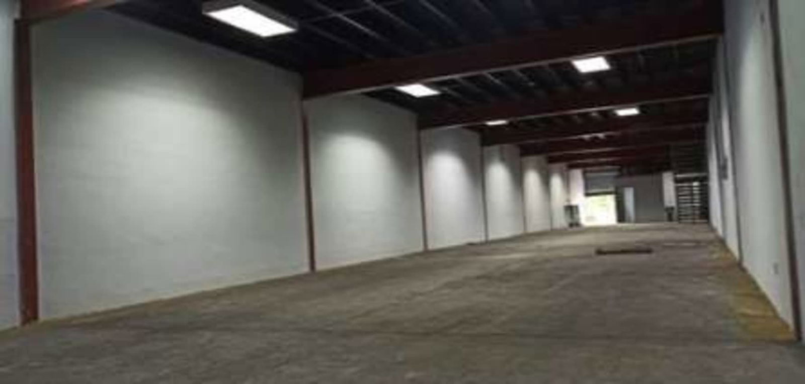 Large empty warehouse interior with concrete flooring and exposed metal beams in Juan Díaz Panama