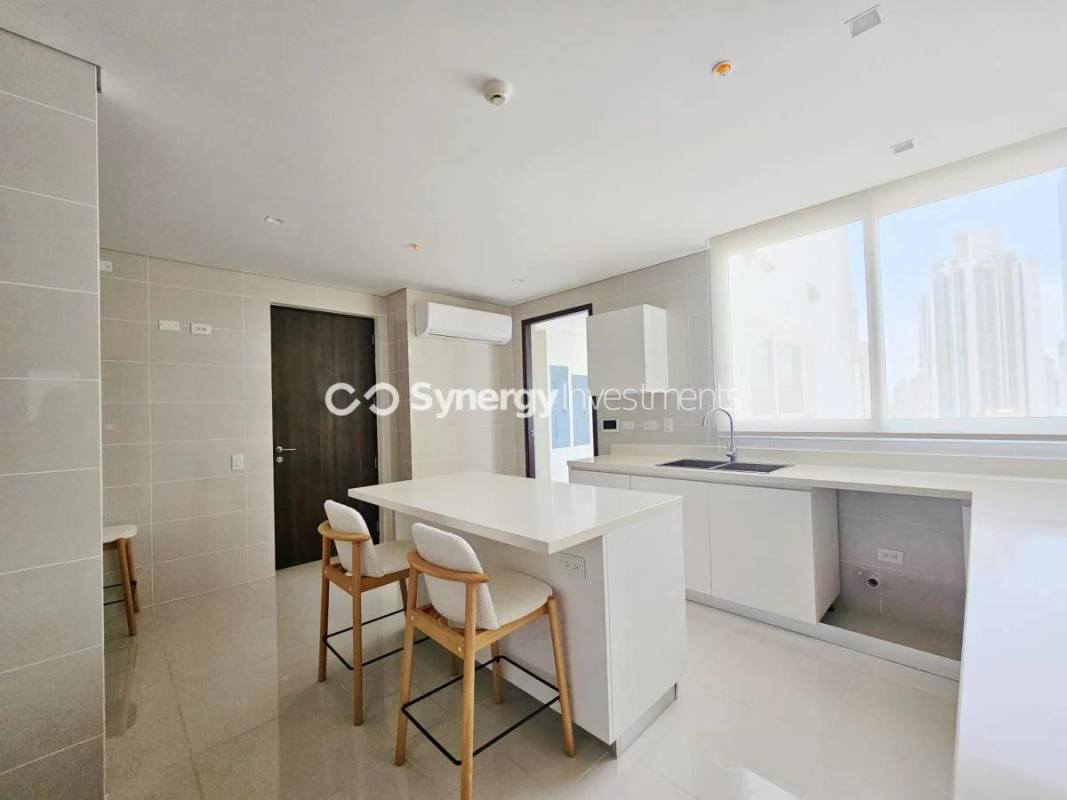 Bright modern kitchen with marble island and built-in cabinetry in Windrose Tower Panama City