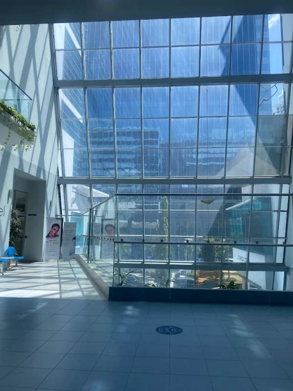 Lobby atrium with floor-to-ceiling glass overlooking Panama City skyline in Pacific Salud Hospital Tower