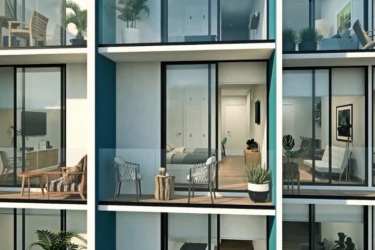 Apartment balconies with glass railings and ocean views at PH Surfside Playa Caracol