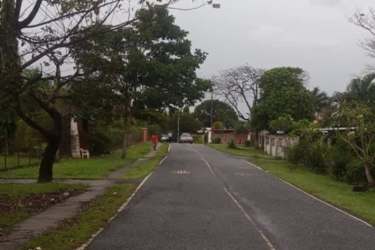 Residential land plot with green lawn, trees, along paved road Las Lajas near Coronado Panama