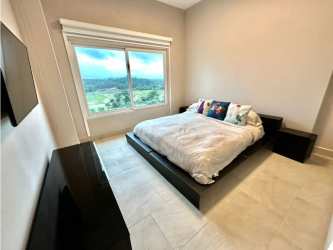 Modern bedroom with large window and balcony access with ocean view at Playa Escondida