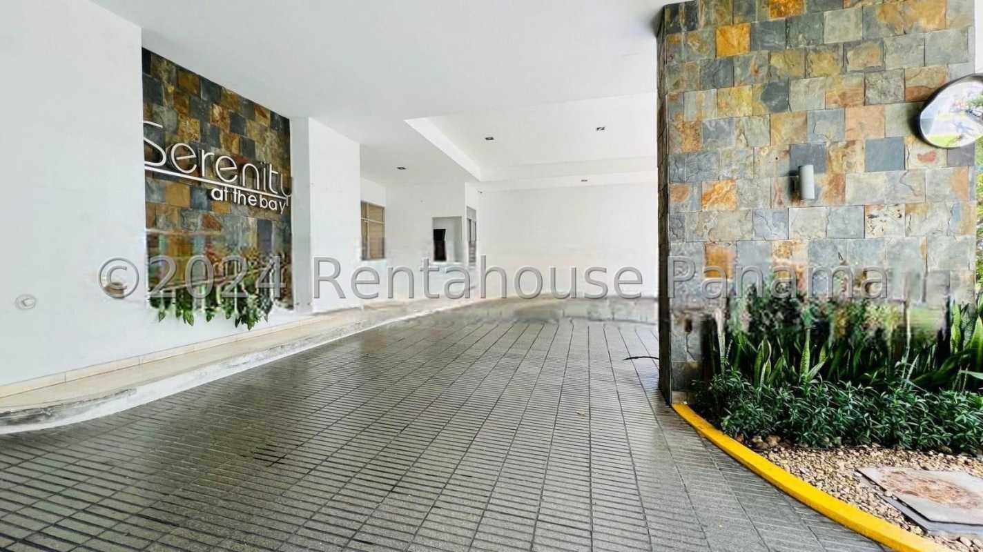 Covered driveway entrance with stone wall and landscaping at PH Serenity at the Bay Panama City