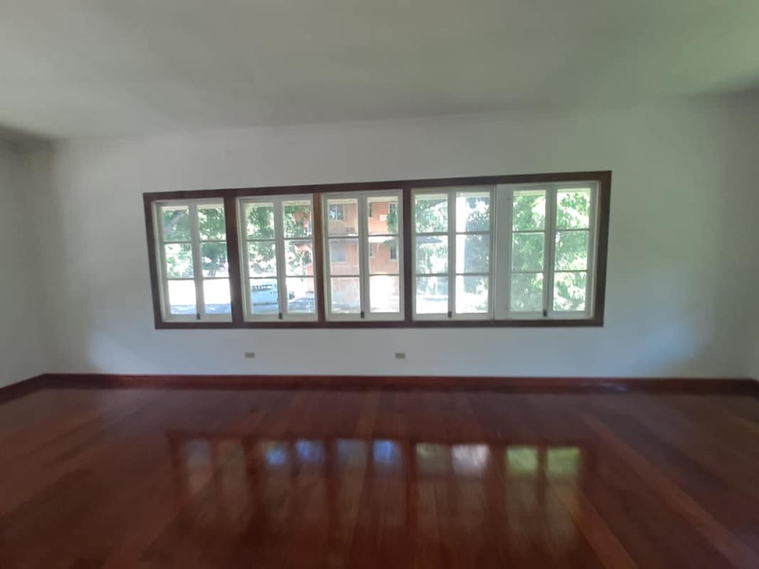Bright living area with hardwood flooring, ample windows, neutral palette in Clayton duplex house Panama
