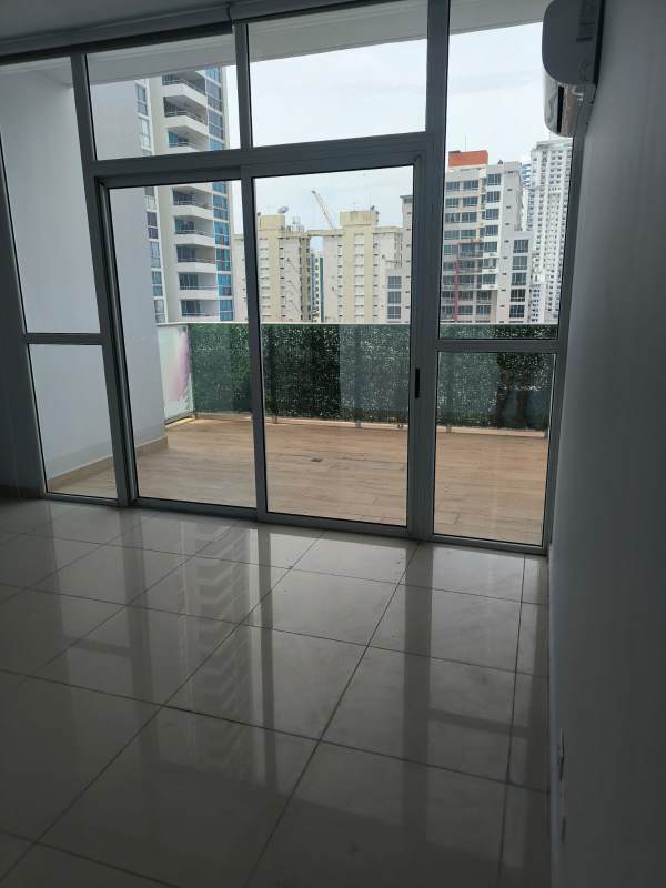 Bright open living dining space with glass doors to balcony at PH Quadrat Panama