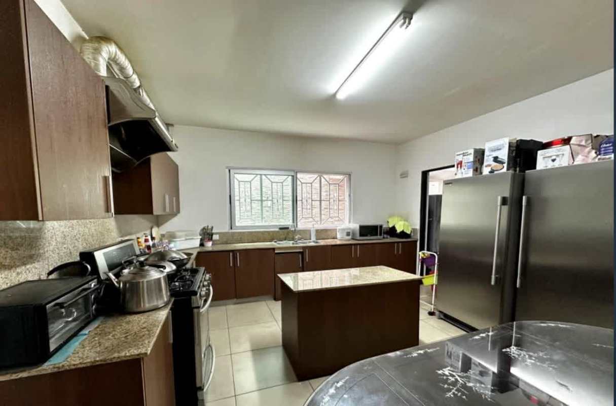 Contemporary kitchen with granite island, stainless appliances and brown cabinets Condado del Rey Panama