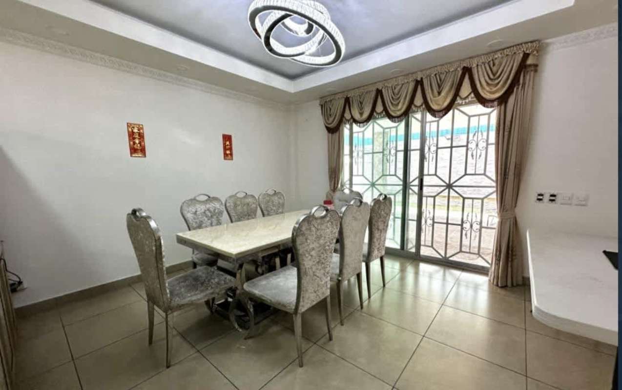 Dining area with large window, marble table, upholstered chairs and modern chandelier Condado del Rey Panama