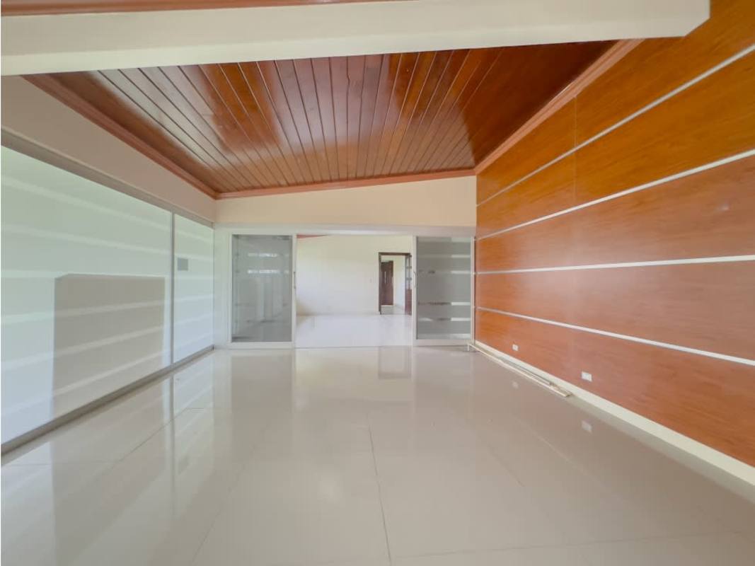 Interior hallway with blue wall, glass brick, wooden ceiling, and natural light in El Carmen house