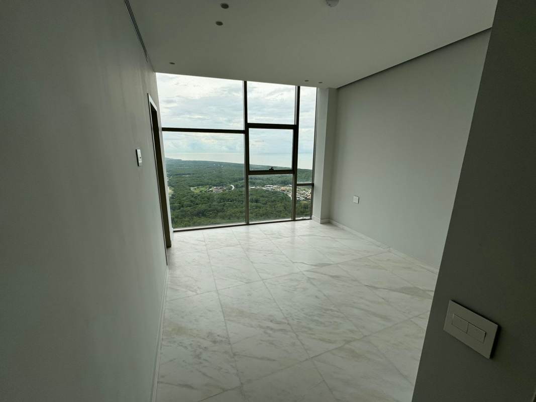 Master bedroom with floor-to-ceiling windows offering skyline and ocean views Santa María Panama