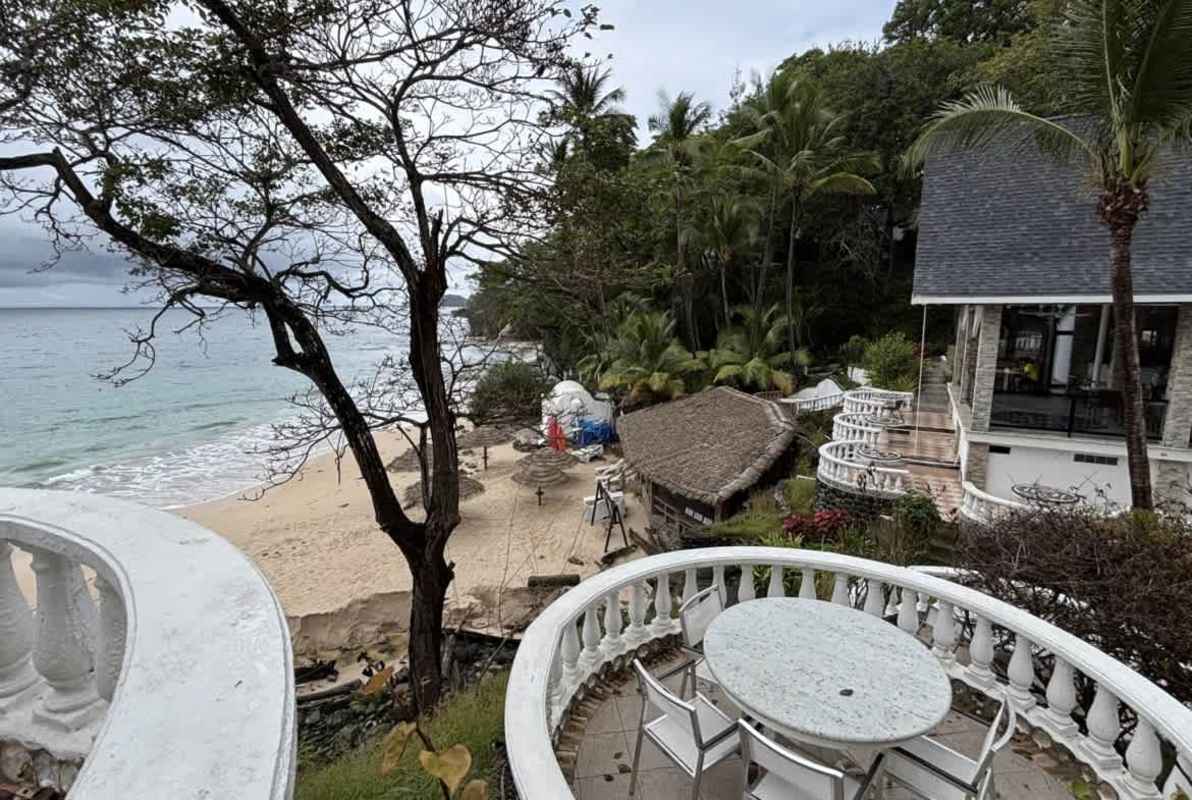 Curved beachfront terrace with stone balustrades, view of sandy beach and tropical palms Isla Contadora