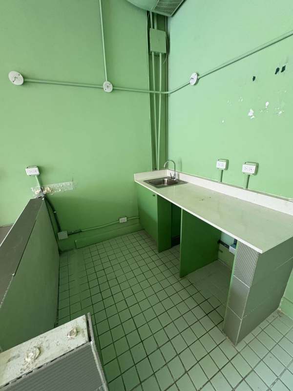 Small utility wash area with sink and green walls inside commercial unit Plaza SF69 Panama.