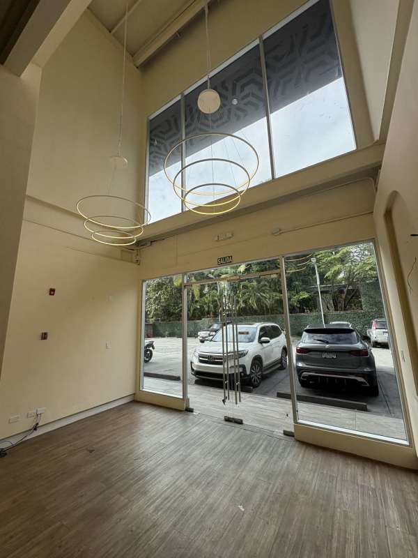 Contemporary commercial building with glass windows, parking lot, landscaping in Plaza SF69 San Francisco Panama.