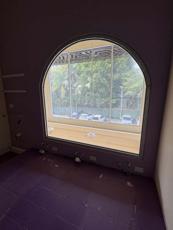 Bathroom with large arched window and plumbing fixtures inside commercial space Plaza SF69 Panama City.