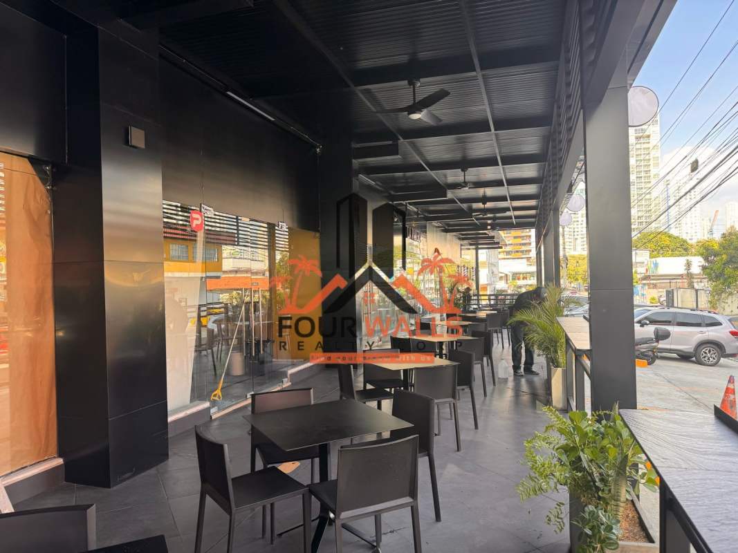 Covered outdoor terrace with black ceiling and glass storefront for customer dining in San Francisco Panama City
