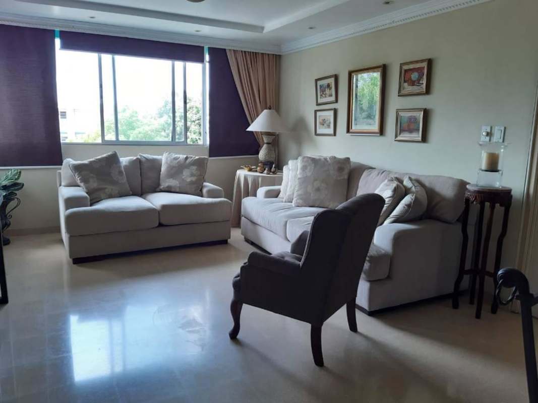 Contemporary living area with sofas, natural light window, and artwork at PH La Alameda Villa de las Fuentes