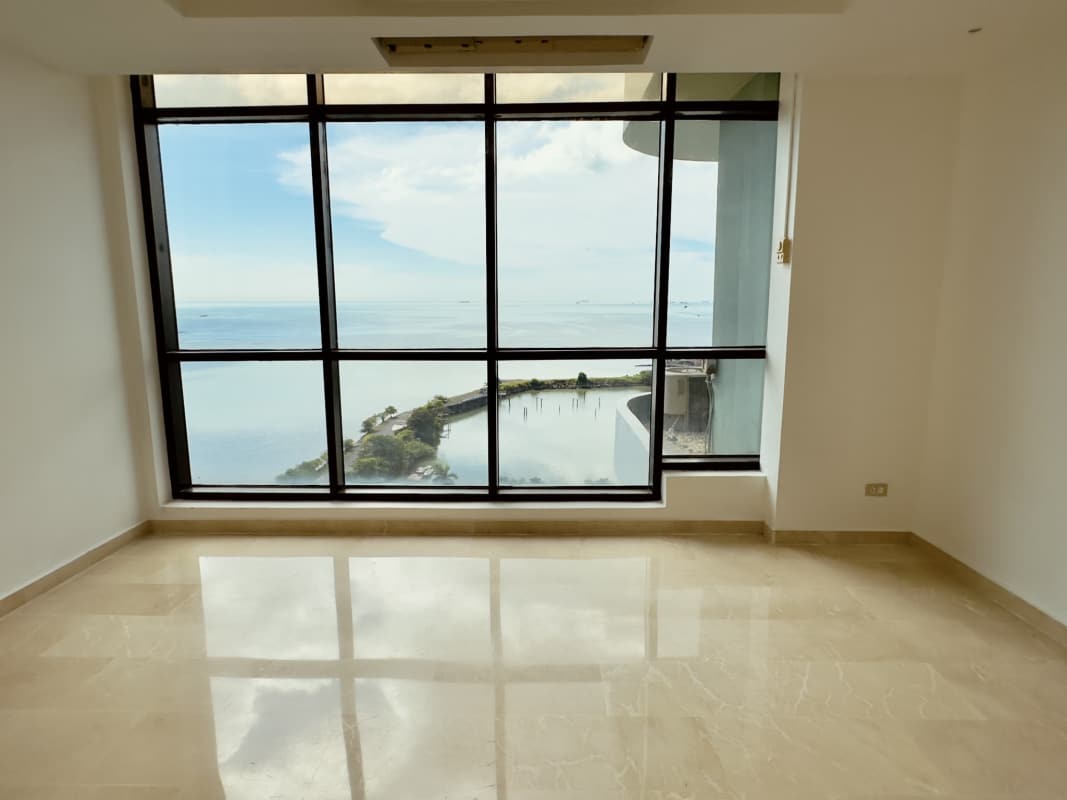 Spacious kitchen with white cabinets black countertops floor-to-ceiling ocean view windows PH Miramar Plaza Panama