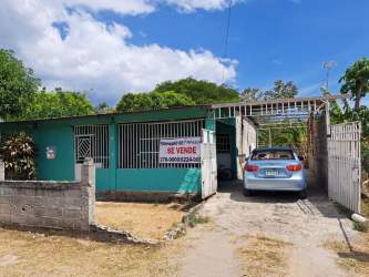 Driveway with blue car and metal gate outside house near Rio Hato Panama