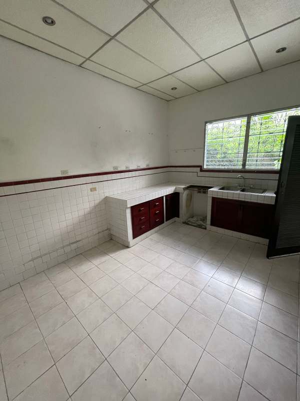 Bright spacious tiled kitchen with window burgundy cabinets commercial Panama