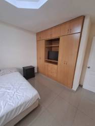 Bedroom space with tile flooring and large window in David central apartment