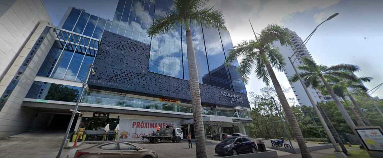 Modern office building entrance with glass and palm trees Costa del Este