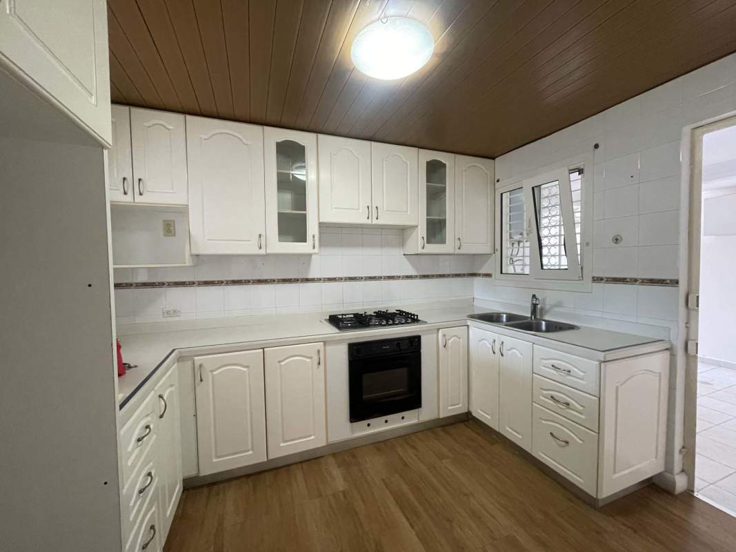 Large traditional kitchen with white cabinetry, gas stove, double sink Betania Panama