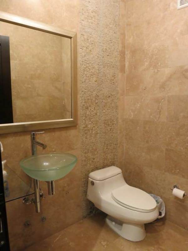 Large bathroom with double sink vanity, marble walls and walk-in shower in PH Ocean Reef Punta Pacifica Panama City