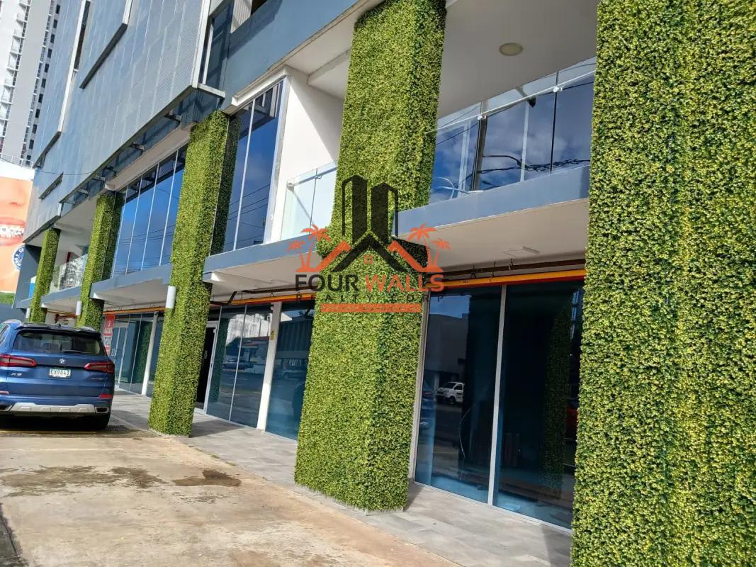 Commercial building with green vertical features, glass frontage, parking along Via España Panama City